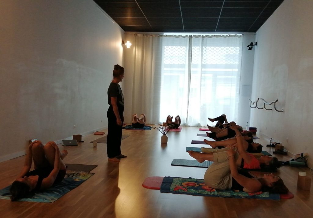 Instructrice guidant une séance de yoga en groupe au studio Benecorps à Perpignan.